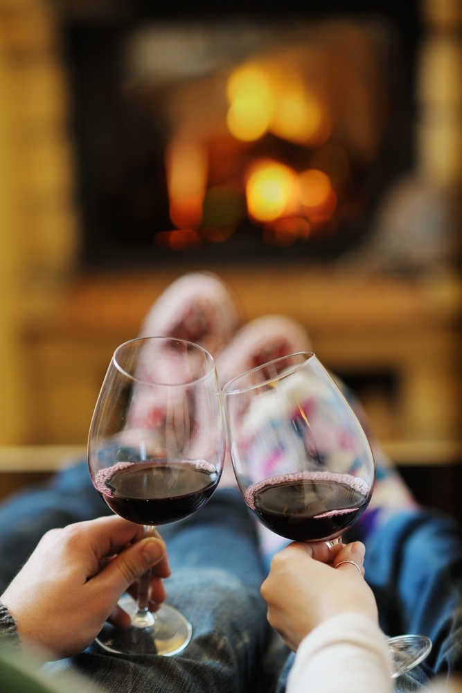 happy Young romantic couple sitting on sofa in front of fireplace at winter season in home